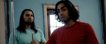 Movie still from “Hostage 911” (2018), directed by Robert Rodriguez – A man with long hair is holding a paintbrush; Close Up shot, Over the shoulder angle