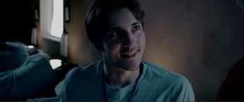 Movie still from “Hostage 911” (2018), directed by Robert Rodriguez – A young man with a beard is smiling for the camera; Close Up shot, Over the shoulder angle