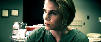 Movie still from “Hostage 911” (2018), directed by Robert Rodriguez – A person wearing a green shirt; Close Up shot, Low angle