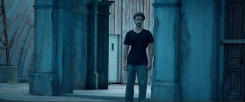 Movie still from “Hostage 911” (2018), directed by Robert Rodriguez – A man standing next to a pillar in a building; Wide shot, Low angle