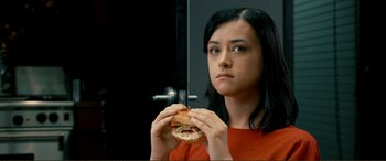 Movie still from “Hostage 911” (2018), directed by Robert Rodriguez – A woman holding a sandwich in front of a mirror; Close Up shot, High angle