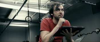Movie still from “Hostage 911” (2018), directed by Robert Rodriguez – A man holding a tablet computer in his hands; Close Up shot, Low angle