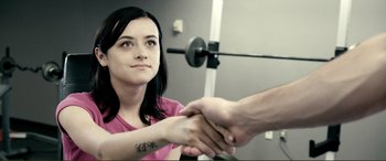 Movie still from “Hostage 911” (2018), directed by Robert Rodriguez – A woman in a pink shirt is shaking hands with a man; Close Up shot, Over the shoulder angle