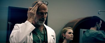 Movie still from “Hostage 911” (2018), directed by Robert Rodriguez – A man and a woman wearing glasses and lab coats; Close Up shot, Low angle