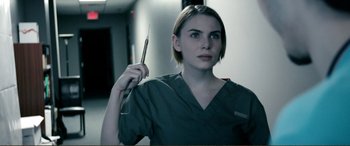 Movie still from “Hostage 911” (2018), directed by Robert Rodriguez – A woman holding a pair of surgical scissors; Close Up shot, Low angle