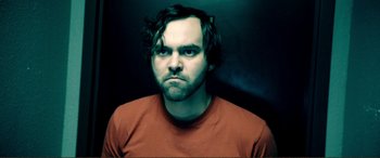 Movie still from “Hostage 911” (2018), directed by Robert Rodriguez – A person wearing a red shirt; Close Up shot, Low angle