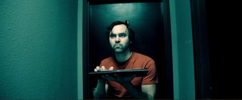 Movie still from “Hostage 911” (2018), directed by Robert Rodriguez – A man is holding a laptop in his hands; Medium shot, Low angle