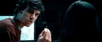 Movie still from “Hostage 911” (2018), directed by Robert Rodriguez – A young man holding a small object in front of a mirror; Close Up shot, Over the shoulder angle