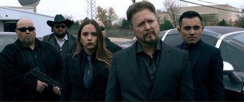 Movie still from “Hostage 911” (2018), directed by Robert Rodriguez – A man and a woman standing next to each other in a parking lot; Medium shot, Over the shoulder angle