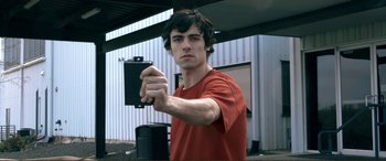 Movie still from “Hostage 911” (2018), directed by Robert Rodriguez – A man holding a cell phone in his hand; Close Up shot, Low angle