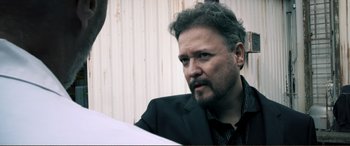 Movie still from “Hostage 911” (2018), directed by Robert Rodriguez – A person wearing a suit and tie; Close Up shot, Over the shoulder angle