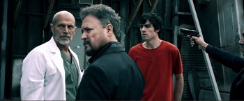 Movie still from “Hostage 911” (2018), directed by Robert Rodriguez – A group of men standing next to each other; Medium shot, Over the shoulder angle