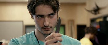 Movie still from “Hostage 911” (2018), directed by Robert Rodriguez – A man holding a knife in his hand; Close Up shot, Over the shoulder angle