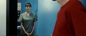 Movie still from “Hostage 911” (2018), directed by Robert Rodriguez – A woman standing in front of a mirror in front of a wall; Close Up shot, Over the shoulder angle