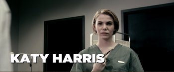 Movie still from “Hostage 911” (2018), directed by Robert Rodriguez – A woman holding a pair of scissors in her hand; Medium shot, Low angle