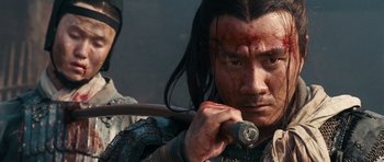 Movie still from “Red Cliff” (2008), directed by John Woo – A man holding a sword in his hands; Close Up shot, Over the shoulder angle