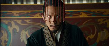 Movie still from “Red Cliff” (2008), directed by John Woo – A man wearing a black robe and a black and white striped tie; Close Up shot, Over the shoulder angle