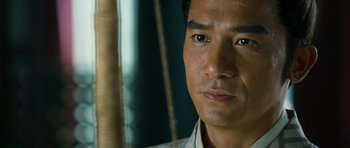 Movie still from “Red Cliff” (2008), directed by John Woo – A man's face in front of a green background; Close Up shot, Over the shoulder angle