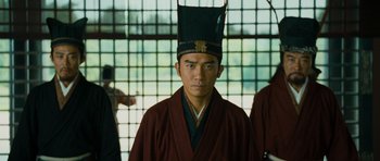 Movie still from “Red Cliff” (2008), directed by John Woo – A young man wearing an oriental hat and robe; Medium shot, Low angle