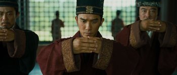 Movie still from “Red Cliff” (2008), directed by John Woo – A man wearing a black hat and a red robe; Close Up shot, Low angle