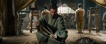 Movie still from “Red Cliff” (2008), directed by John Woo – A man in traditional japanese garb working in a workshop; Medium shot, Low angle