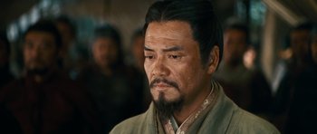 Movie still from “Red Cliff” (2008), directed by John Woo – A man with long black hair and a beard; Close Up shot, Over the shoulder angle