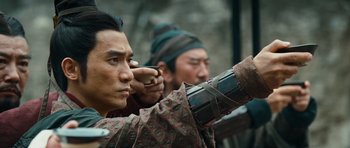 Movie still from “Red Cliff” (2008), directed by John Woo – Two men in traditional chinese garb , one of which is holding a sword; Close Up shot, Over the shoulder angle