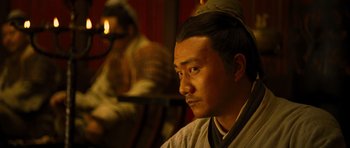 Movie still from “Red Cliff” (2008), directed by John Woo – A man with a hat sitting in front of another man; Close Up shot, Over the shoulder angle