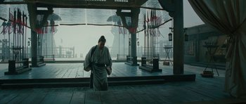 Movie still from “Red Cliff” (2008), directed by John Woo – A man in traditional japanese garb standing in front of an open window; Wide shot, Low angle
