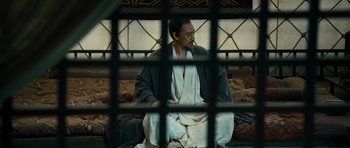 Movie still from “Red Cliff” (2008), directed by John Woo – A man sitting on top of a couch wearing a robe; Medium shot, High angle