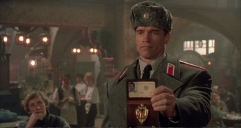 Movie still from “Red Heat” (1988), directed by Walter Hill – A man in a military uniform holding up a badge; Close Up shot, Over the shoulder angle