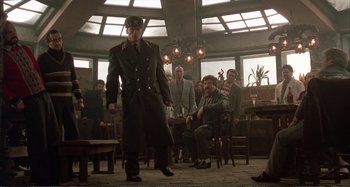 Movie still from “Red Heat” (1988), directed by Walter Hill – A group of men sitting in a room; Wide shot, Low angle