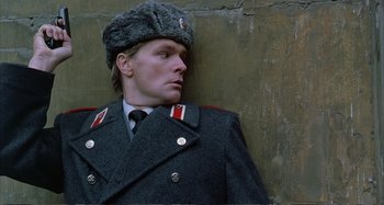 Movie still from “Red Heat” (1988), directed by Walter Hill – A man in a military uniform leaning up against a wall; Close Up shot, Low angle