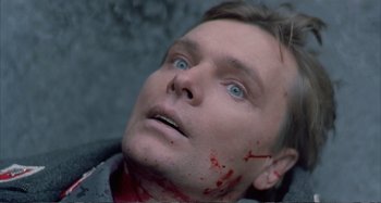 Movie still from “Red Heat” (1988), directed by Walter Hill – A person with blood on his face; Close Up shot, Overhead angle