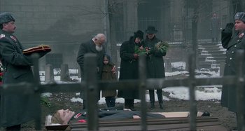 Movie still from “Red Heat” (1988), directed by Walter Hill – A group of people standing next to a man laying on the ground; Wide shot, High angle