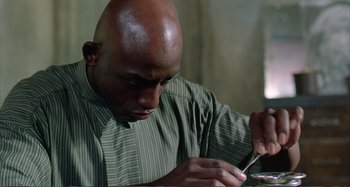 Movie still from “Red Heat” (1988), directed by Walter Hill – A bald man is looking at his cell phone; Close Up shot, Low angle