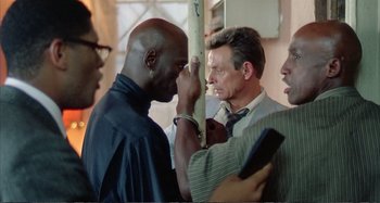 Movie still from “Red Heat” (1988), directed by Walter Hill – A man with his hands on his face and another man with his hands on his head; Close Up shot, Over the shoulder angle