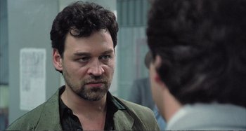 Movie still from “Red Heat” (1988), directed by Walter Hill – A person looking at a mirror; Close Up shot, Over the shoulder angle