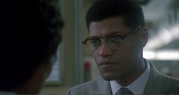 Movie still from “Red Heat” (1988), directed by Walter Hill – A person wearing a suit and glasses; Close Up shot, Over the shoulder angle