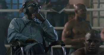 Movie still from “Red Heat” (1988), directed by Walter Hill – A man sitting in a chair with headphones on his ears; Medium shot, High angle