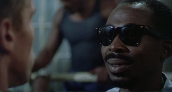 Movie still from “Red Heat” (1988), directed by Walter Hill – A person wearing sunglasses; Close Up shot, Low angle