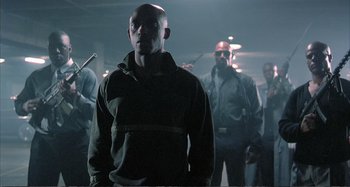 Movie still from “Red Heat” (1988), directed by Walter Hill – A group of men standing in a dark room; Medium shot, Low angle
