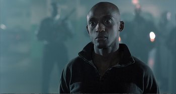 Movie still from “Red Heat” (1988), directed by Walter Hill – A man in a black jacket is looking at the camera; Close Up shot, Low angle