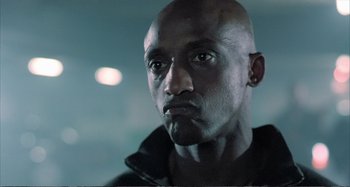 Movie still from “Red Heat” (1988), directed by Walter Hill – A man with a bald head is looking at the camera; Close Up shot, Low angle