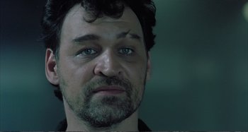 Movie still from “Red Heat” (1988), directed by Walter Hill – A person with a beard and blue eyes; Close Up shot, Low angle