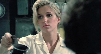 Movie still from “Red Heat” (1988), directed by Walter Hill – A woman in a white shirt is posing for a picture; Close Up shot, Over the shoulder angle