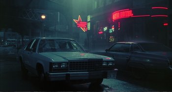 Movie still from “Red Heat” (1988), directed by Walter Hill – A car parked on the side of the road at night; Wide shot, Low angle