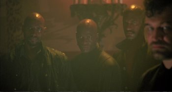 Movie still from “Red Heat” (1988), directed by Walter Hill – A group of men standing next to each other in a room; Medium shot, Low angle