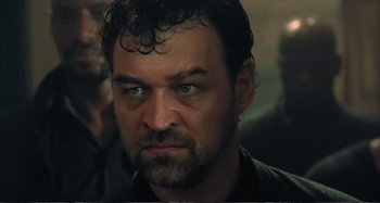 Movie still from “Red Heat” (1988), directed by Walter Hill – A person wearing a black shirt; Close Up shot, Low angle