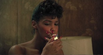 Movie still from “Red Heat” (1988), directed by Walter Hill – A woman smoking a cigarette in a bathroom; Close Up shot, High angle